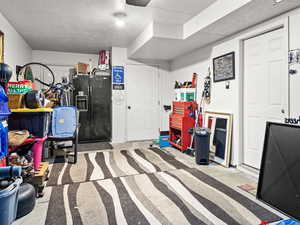 Garage featuring black refrigerator with ice dispenser