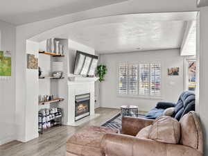 Living room with light hardwood / wood-style flooring and a tiled fireplace