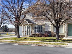 View of front of property featuring a front lawn and a garage