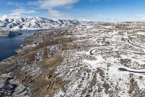 Snowy aerial view featuring a water and mountain view