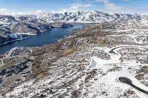 Snowy aerial view with a water and mountain view