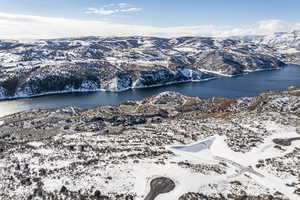 Snowy aerial view with a water and mountain view