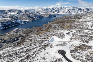 Snowy aerial view with a water and mountain view