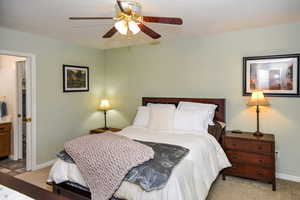 Bedroom with ceiling fan and light carpet