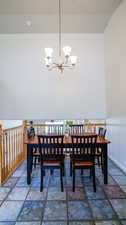 Dining space with lofted ceiling and an inviting chandelier