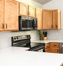 Kitchen with stunning tile backsplash, quartz countertops, and stainless steel appliances