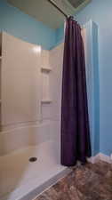 Bathroom featuring a shower with curtain and toilet