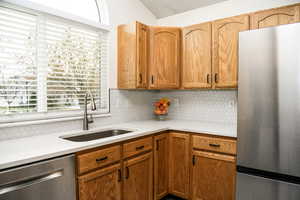 Kitchen with stainless steel appliances, quartz countertops, tasteful backsplash, and sink