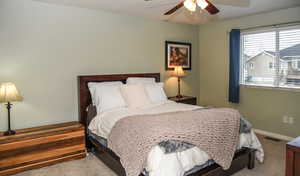 Bedroom with ceiling fan and light colored carpet