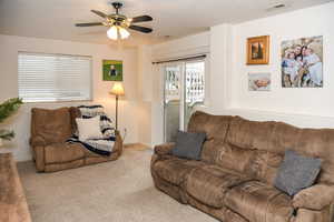 Living room with light colored carpet and ceiling fan