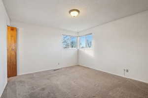 Carpeted spare room with a textured ceiling