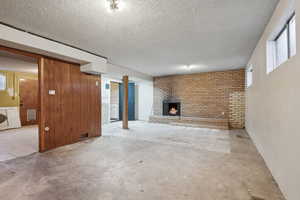 Unfurnished living room featuring a fireplace and a textured ceiling