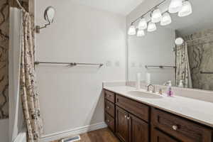 Bathroom featuring vanity, wood-type flooring, and shower / bath combo