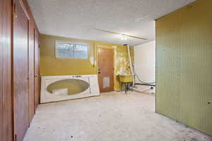 Basement with washer / dryer, a textured ceiling, and sink