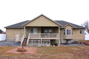 Rear view of house featuring covered deck (above) and covered patio (below) and an outdoor fire pit