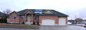 View of front facade with solar panels and a garage