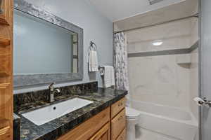 Full bathroom featuring vanity, toilet, and shower / bath combo with shower curtain