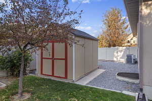 View of outbuilding featuring a lawn and cooling unit