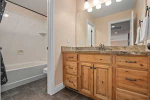 Full bathroom featuring vanity, toilet, and shower / bathtub combination with curtain