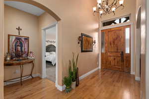 Foyer entrance with a notable chandelier and light wood-type flooring