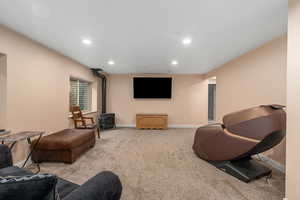 Living room featuring light carpet and a wood stove