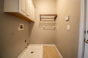 Laundry area featuring cabinets, washer hookup, hookup for an electric dryer, hookup for a gas dryer, and light tile patterned flooring