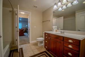 Bathroom featuring toilet, vanity, and tile patterned floors