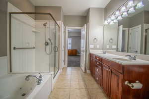 Bathroom with tile patterned flooring, vanity, and separate shower and tub