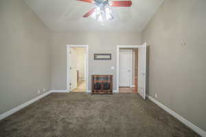 Master bedroom with ceiling fan, light colored carpet, and master  bathroom.