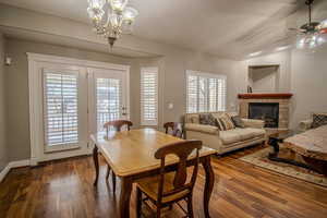 Dining space featuring lofted ceiling, ceiling fan with notable chandelier, and hardwood / wood-style flooring