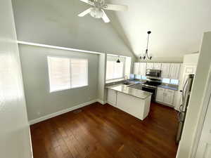 Kitchen featuring pendant lighting, white cabinets, sink, appliances with stainless steel finishes, and kitchen peninsula