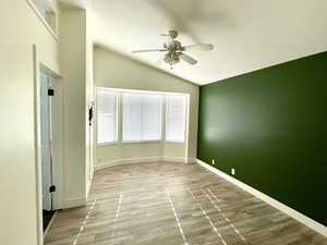 Spare room featuring ceiling fan, light hardwood / wood-style flooring, and vaulted ceiling