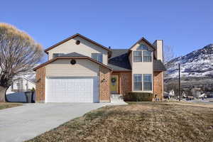 View of property featuring a front yard and a garage