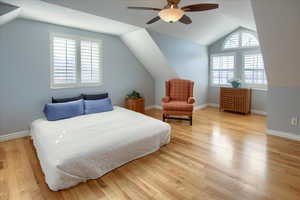 Bedroom with ceiling fan, light hardwood / wood-style flooring, and vaulted ceiling