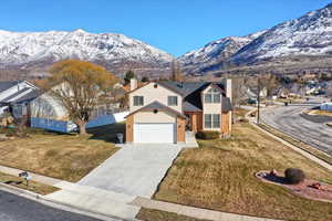 View of front of property with a mountain view and a front lawn