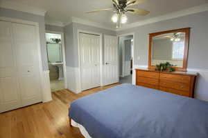 Bedroom featuring ceiling fan, light hardwood / wood-style floors, connected bathroom, and multiple closets