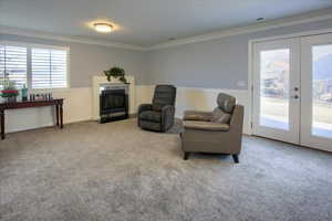 Sitting room featuring light colored carpet, ornamental molding, and french doors