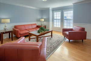 Living room featuring light hardwood / wood-style flooring and ornamental molding