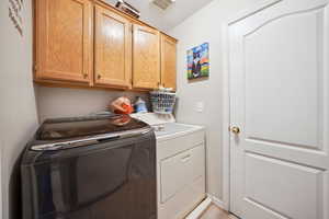 Clothes washing area with cabinets and washing machine and dryer