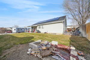 Exterior space featuring a yard and solar panels. Solar Panels are financed.