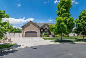 View of front of property featuring a garage and a front lawn