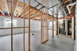 Basement featuring water heater and a wealth of natural light