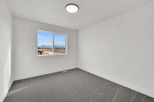 Carpeted empty room featuring a mountain view