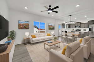 Living room with light hardwood / wood-style flooring and ceiling fan