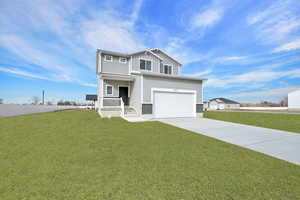 View of front facade featuring a porch, a garage, and a front lawn