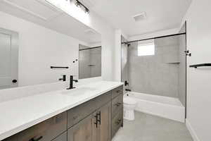 Full bathroom featuring vanity, toilet, and tiled shower / bath