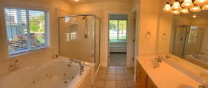 Bathroom with tile patterned flooring, vanity, and separate shower and tub