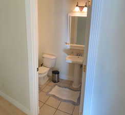 Bathroom featuring tile patterned flooring, toilet, and sink