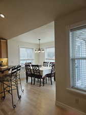 Dining room featuring light wood-type flooring and an inviting chandelier