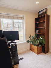 Carpeted home office with crown molding